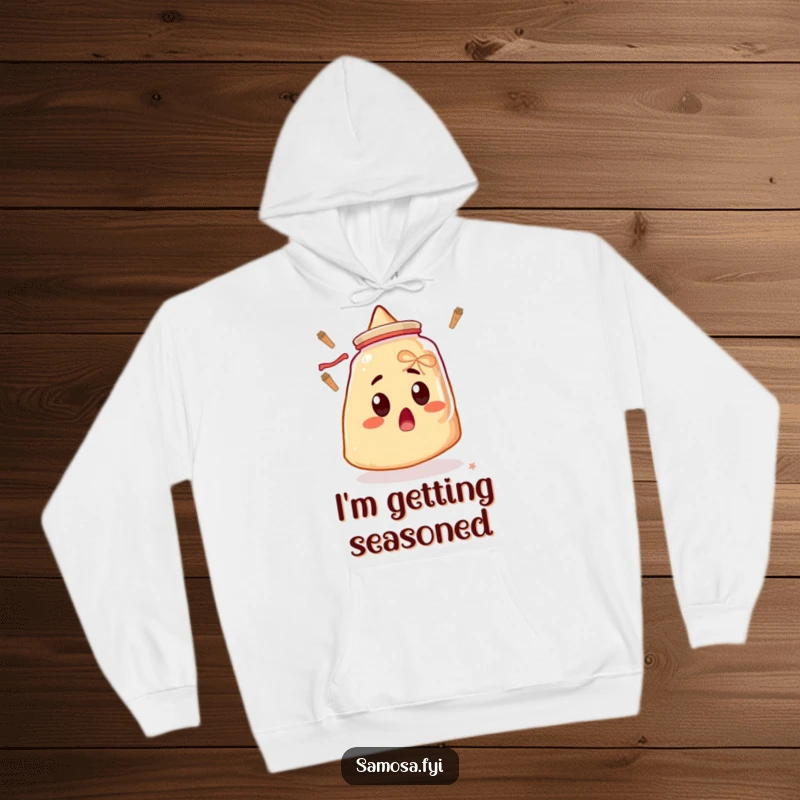 Funny hoodie depicting a surprised samosa with wide eyes, fixated on a mysteriously floating spice jar, great for humor lovers.